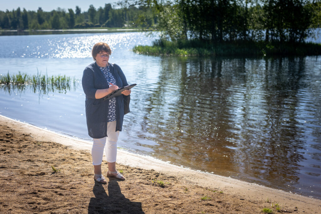 Hämeenlinnan kaupungin terveystarkastaja Päivi Lindén tekee muistiinpanoja uimarannalla.